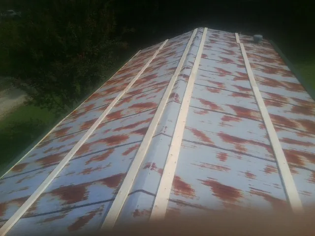 Rusted metal roof panels with new wood purlins before replacement — Storm Damage Roof Repair in Wheatland by Roofing Brothers